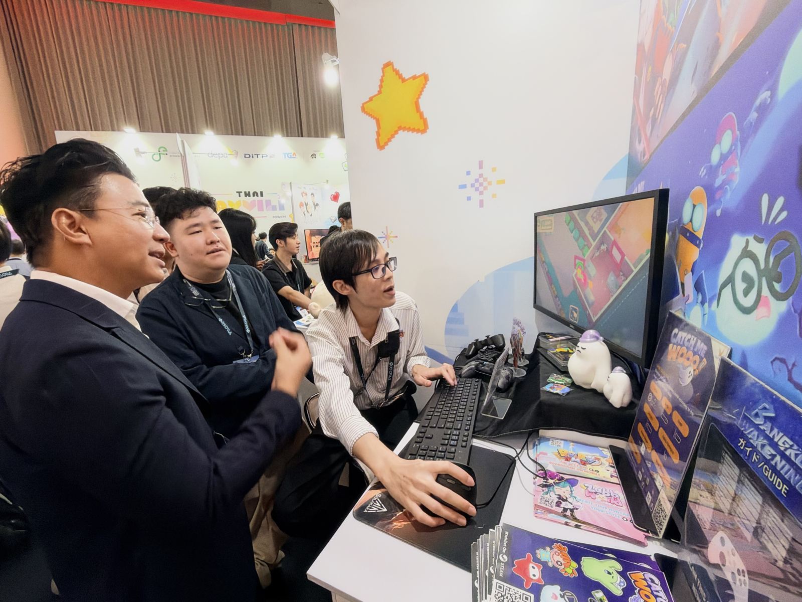 ผู้เข้าชมต่างชาติพูดคุยและเล่นเกมที่บูธเกมไทย